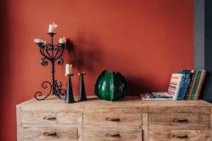 świece oraz książki ułożone na drewnianej komodzie